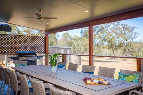 a patio with a table and chairs and a grill at Amani in Pokolbin