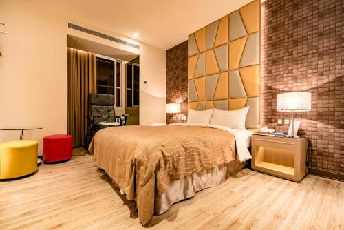 a hotel room with a bed and a brick wall at Eusta Motel in Taichung
