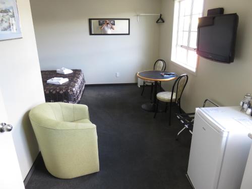 a room with a table and a chair and a table at Admirals Motor Lodge in Blenheim