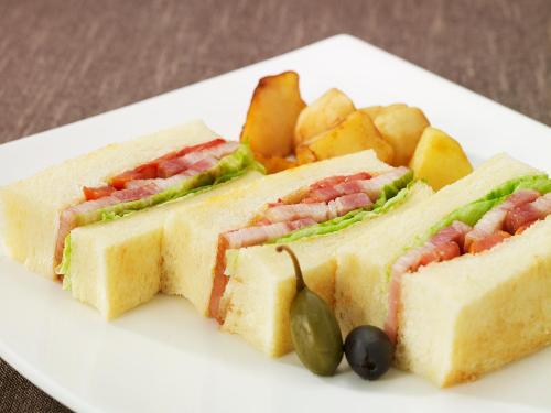 a sandwich and chips on a white plate at The Prince Sakura Tower Tokyo, Autograph Collection in Tokyo