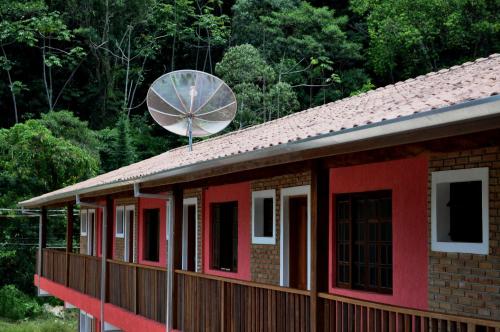 a red house with a satellite dish on top of it at Chalés Buriti in Caraguatatuba