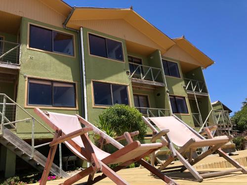 two lawn chairs sitting in front of a building at Delfín Apart in Pichilemu