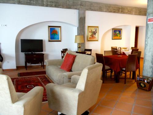 a living room with a couch and chairs and a table at Casa do Largo - Golegã - Turismo de Habitação in Golegã