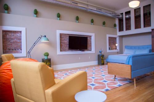a living room with a blue couch and a tv at School 31 Lofts in Rochester