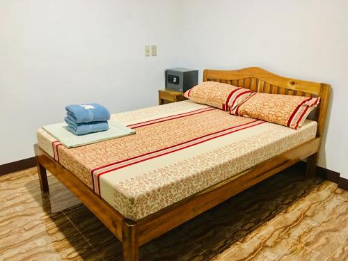 a bed with a wooden frame with a hat on it at Pisces Tourist Inn - Port Barton in San Vicente