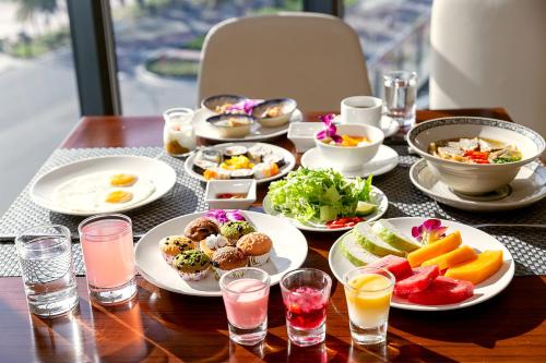 a table topped with plates of food and drinks at The Nalod Da Nang in Da Nang