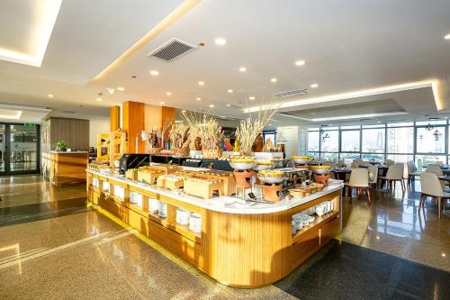 a restaurant with a counter with tables and chairs at The Nalod Da Nang in Da Nang