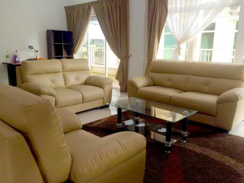 a living room with two couches and a coffee table at Melaka Homestay Tiara Golf Resort in Malacca