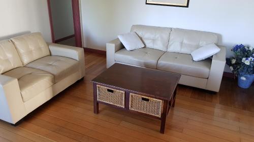 a living room with two couches and a coffee table at Cedar Cottages Blackmans Bay in Kingston