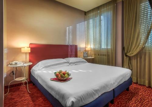a bedroom with a bed with a bowl of fruit on it at Hotel Maggiore in Bologna