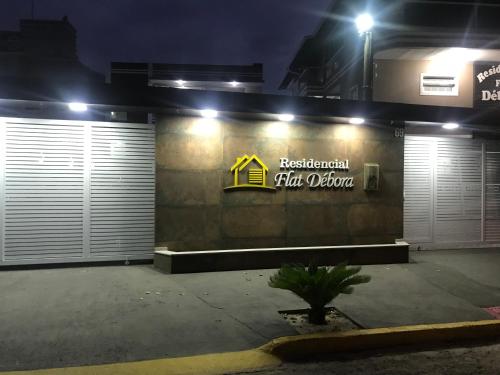 a building with two garage doors and a sign on it at Residencial Flat Debora in Florianópolis
