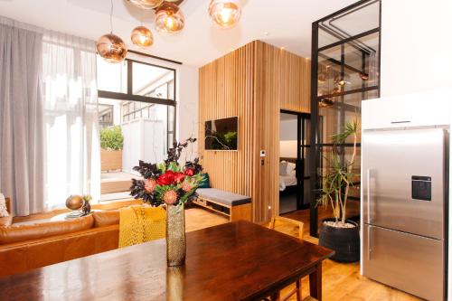 a living room with a table and a refrigerator at Auckland City Spacious Loft - 4 Bedrooms & 2 Free Car Parks in Auckland