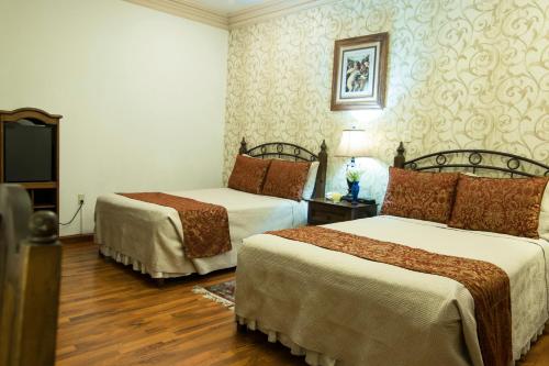 a hotel room with two beds in a room at Hotel Casa Divina Oaxaca in Oaxaca City
