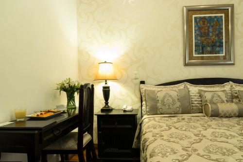 a bedroom with a bed and a desk with a lamp at Hotel Casa Divina Oaxaca in Oaxaca City