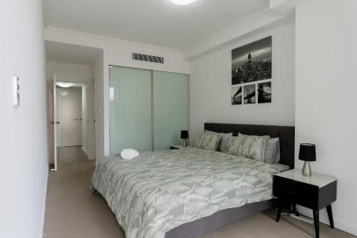 a bedroom with a large bed and a black table at 91 Liverpool Street, World Tower in Sydney