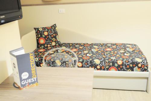 a bed with a comforter and a box at Hotel Maggiore in Bologna