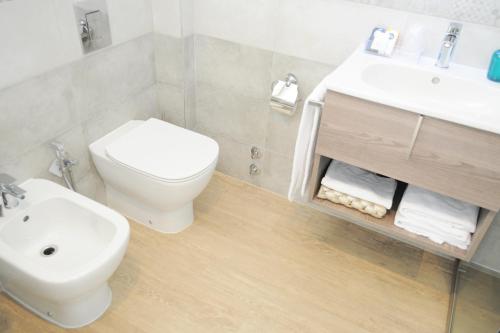 a white bathroom with a toilet and a sink at Hotel Maggiore in Bologna