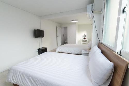 a bedroom with two beds and a window at Kpop Haus in Seoul