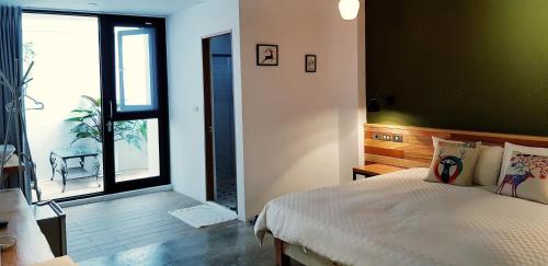 a bedroom with a bed and a large window at The Red Hotel in Nanwan