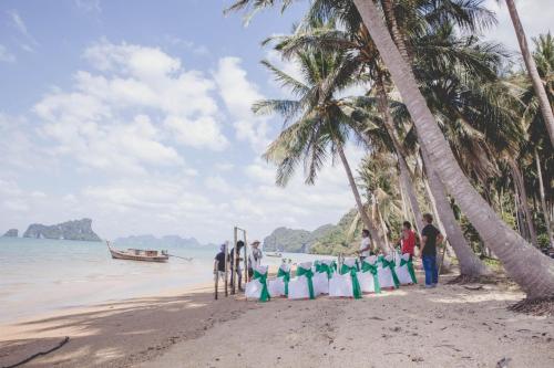 a group of people standing on a beach at Tukonnee Villas Koh Yao Noi in Ko Yao Noi