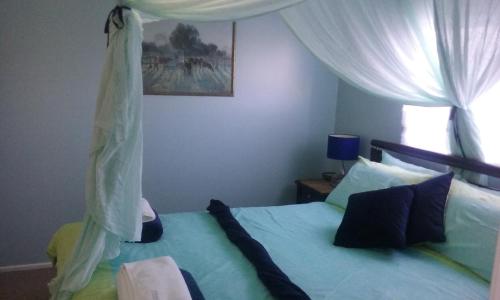 a bedroom with a bed with a canopy at oceanview 6 with rooftop terrace & spa in Nambucca Heads