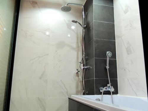 a bathroom with a shower with a tub and a sink at The Raise Hotel in Hat Yai