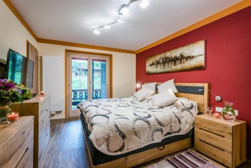ein Schlafzimmer mit einem Bett und einer roten Wand in der Unterkunft Ferienparadies Alpenglühn in Berchtesgaden