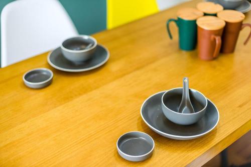 a wooden table with three cups and saucers on it at Henan Luoyang·Chanhe Hui Nationality Area· Locals Apartment 00144150 in Luoyang