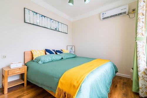 a bedroom with a bed with a yellow and blue blanket at Henan Luoyang·Chanhe Hui Nationality Area· Locals Apartment 00144150 in Luoyang
