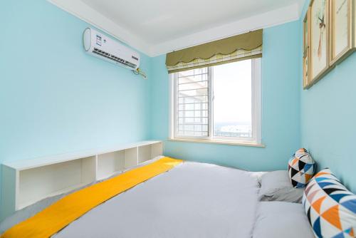a blue room with a bed and a window at Henan Luoyang·Chanhe Hui Nationality Area· Locals Apartment 00144150 in Luoyang