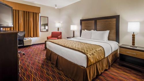 una habitación de hotel con una cama grande y una silla roja en Best Western B R Guest, en Zanesville