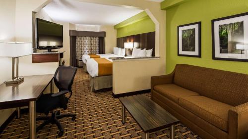 a hotel room with a bed and a couch at Best Western Knoxville Suites - Downtown in Knoxville