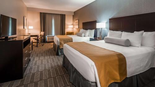 a hotel room with two beds and a television at Best Western Plus The Hammondsport Hotel in Hammondsport