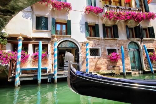 a gondola parked in front of a building with flowers at Hotel Colombina in Venice