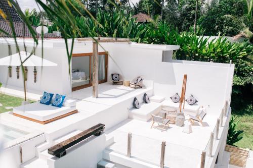 a white house with chairs and plants at The Apartments Ubud in Ubud