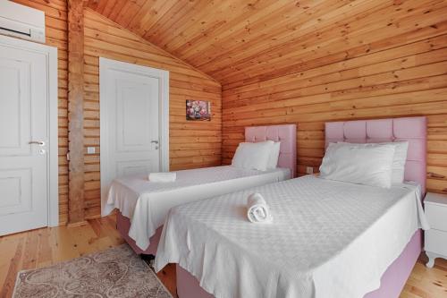 カルカンにあるEco Villa Melisaのベッド2台 木製の壁の部屋