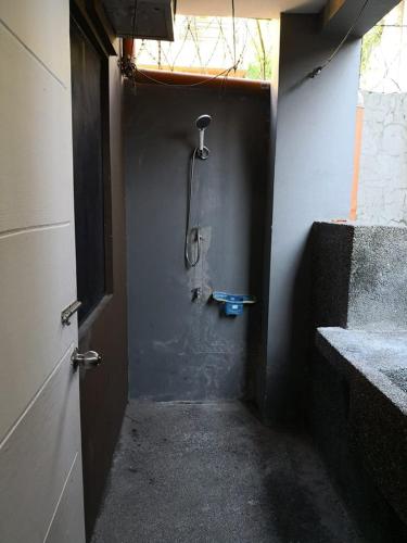 a bathroom with a shower in the corner of a room at Anabelle Residence in Dumaguete