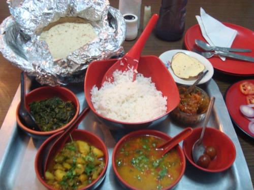 een dienblad met kommen eten op tafel bij Pahari Soul in Darjeeling