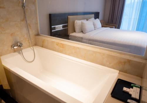 a bathroom with a tub and a bed in a room at Cahaya Villa Garut in Garut
