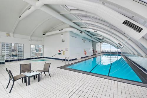 a large swimming pool with chairs and a table in a building at Darling Harbour Getaway in Sydney