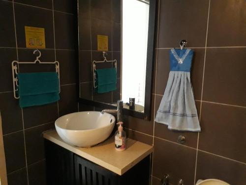 a bathroom with a sink and a dress hanging in a window at Gold Coast Morib Resort in Banting