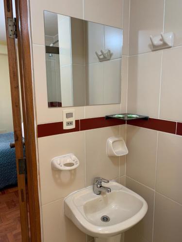 a bathroom with a sink and a mirror at Residencial Alta Vista in La Paz