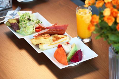 花蓮市的住宿－花蓮S.E.A.民宿 藍海曙光，一张桌子,上面放着两盘食物和一杯橙汁