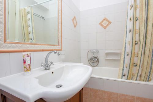 a bathroom with a sink and a bath tub at Irida Holiday Home in Naxos Chora