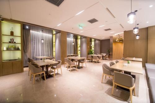 a restaurant with tables and chairs and windows at Zenith Hotel-Near Train Station & The Mixc in Xiamen