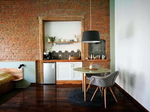 a kitchen with a table and a brick wall at Zada Studio in Braşov