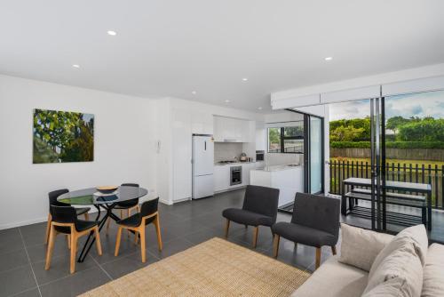 a living room with a couch and a table and chairs at Oxford Steps - Executive 2BR Bulimba Apartment Across from the Park on Oxford St in Brisbane