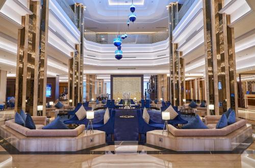 a lobby with couches and tables in a building at The Diplomat Radisson Blu Residence in Manama