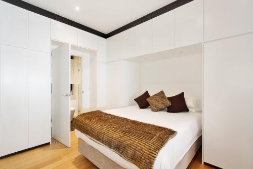 um quarto com uma cama grande e paredes brancas em Little New York on Riley - Executive 1BR Darlinghurst Apartment with New York Laneway Feel em Sydney