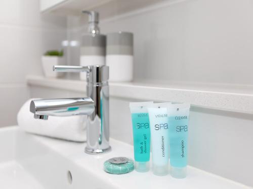 a bathroom sink with two tubes of toothpaste on it at The Junction Palais - Modern and Spacious 2BR Bondi Junction Apartment Close to Everything in Sydney
